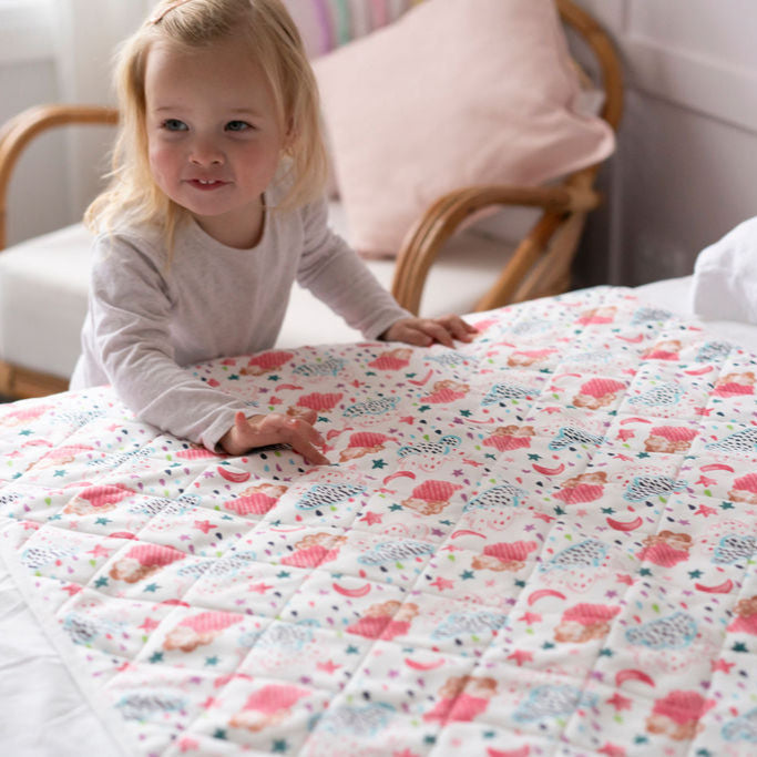 Child playing on a bed with a Rainclouds Bed Mat