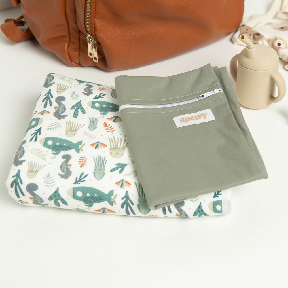 
                      
                        Underwater World Spewy with a Grey Wet Bag positioned in front of a Nappy Bag, showing that it's perfect to take on the go.
                      
                    