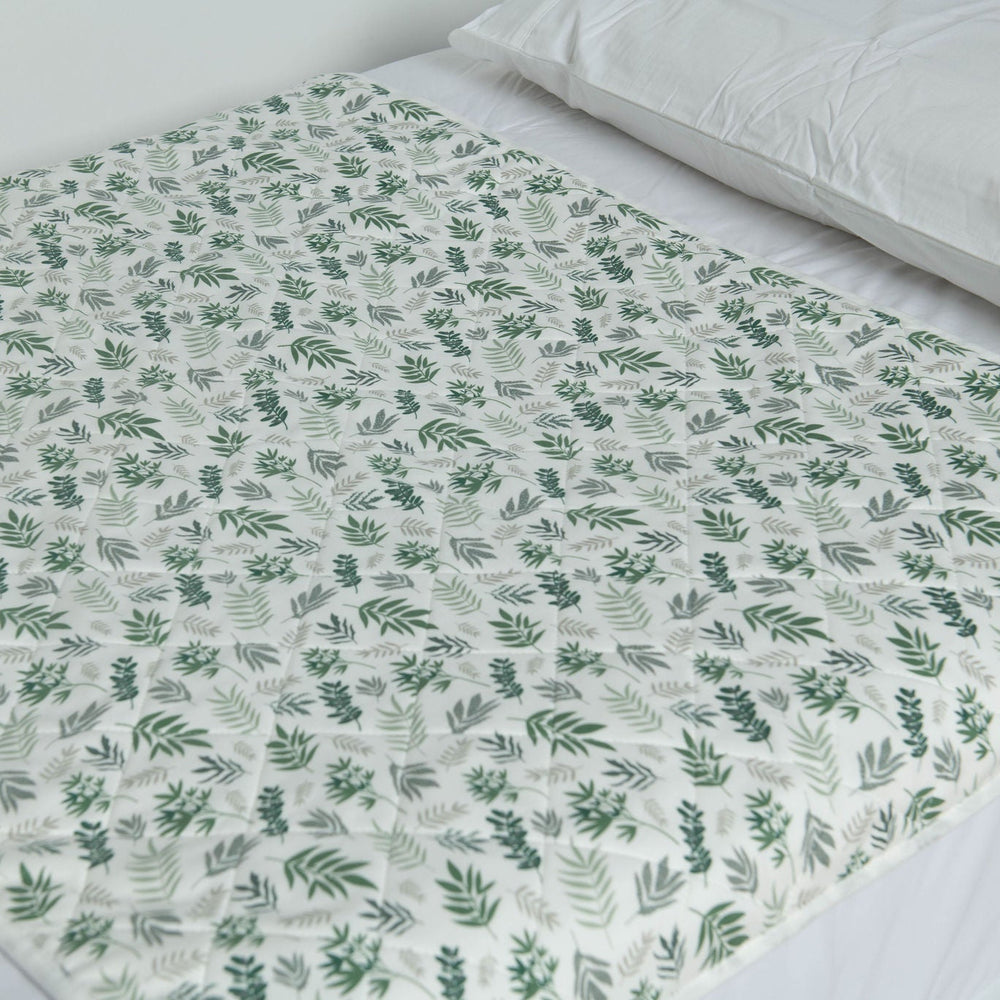 A close up photo of the Bed Mat on a bed in the Lost in Leaves design. 