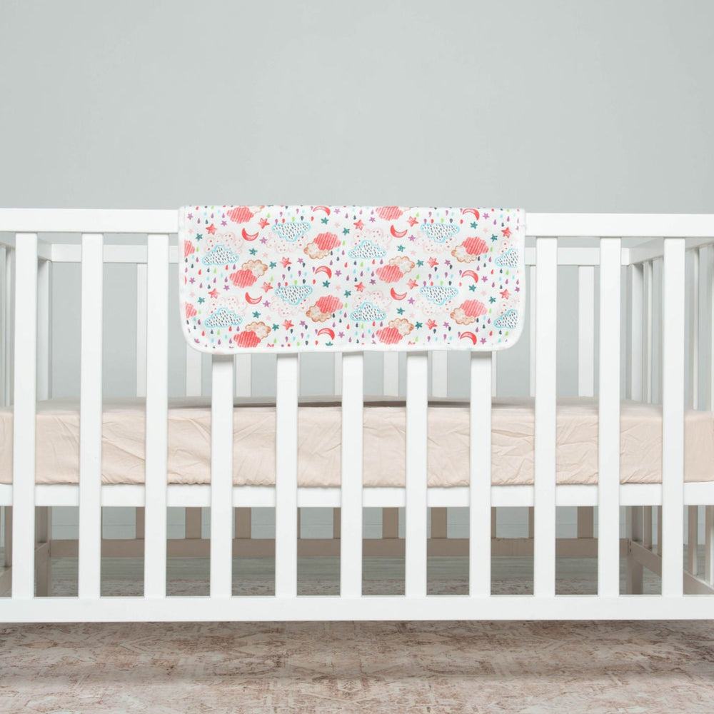
                      
                        White crib with floral bumper pad on a gray background
                      
                    