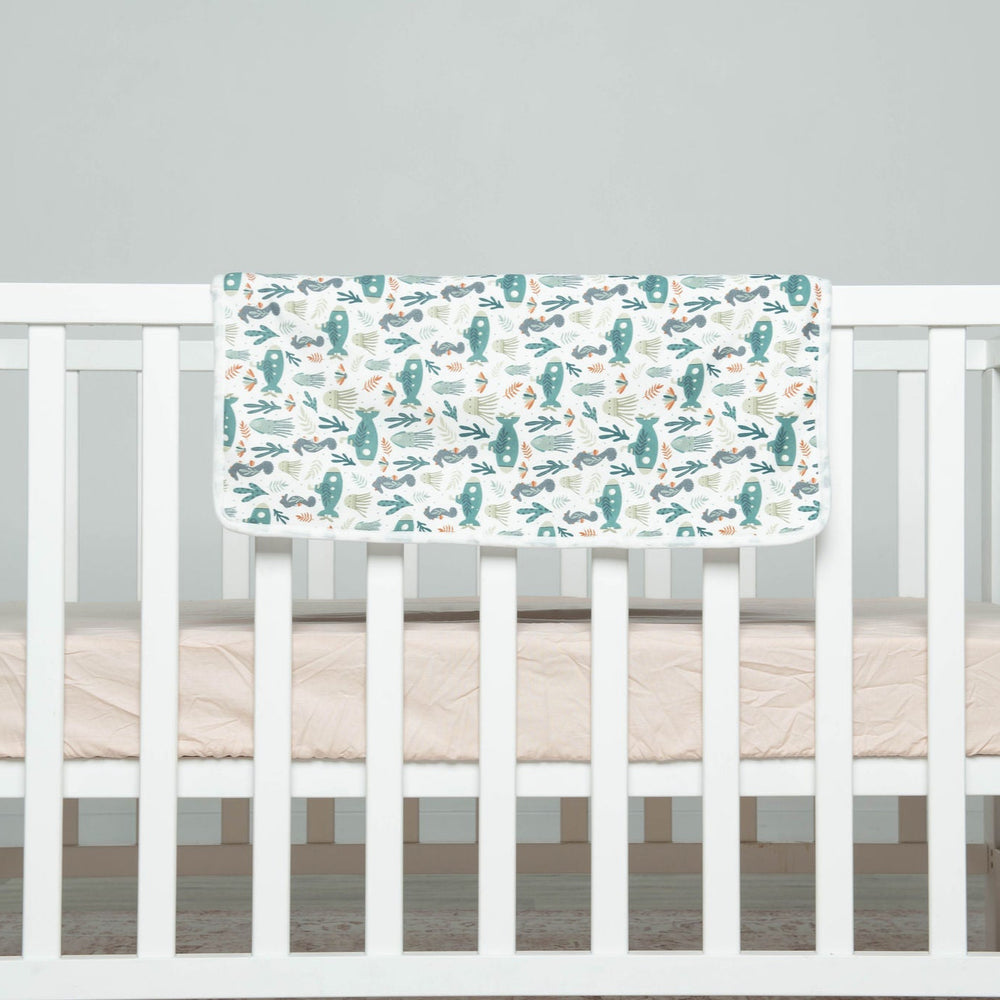 
                      
                        White crib with a crib sheet featuring Underwater patterns on a gray background
                      
                    